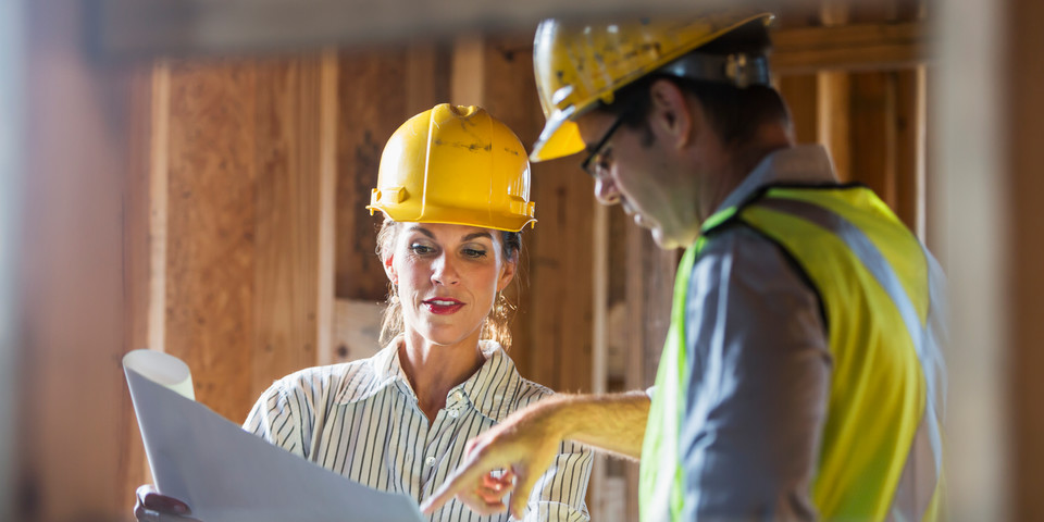 arkitekter eller ingenjörer med arkitektskiss på byggarbetsplats