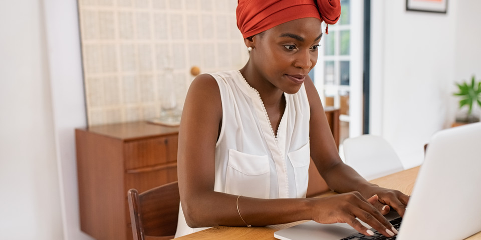 person sitting by a table working on a laptop computer